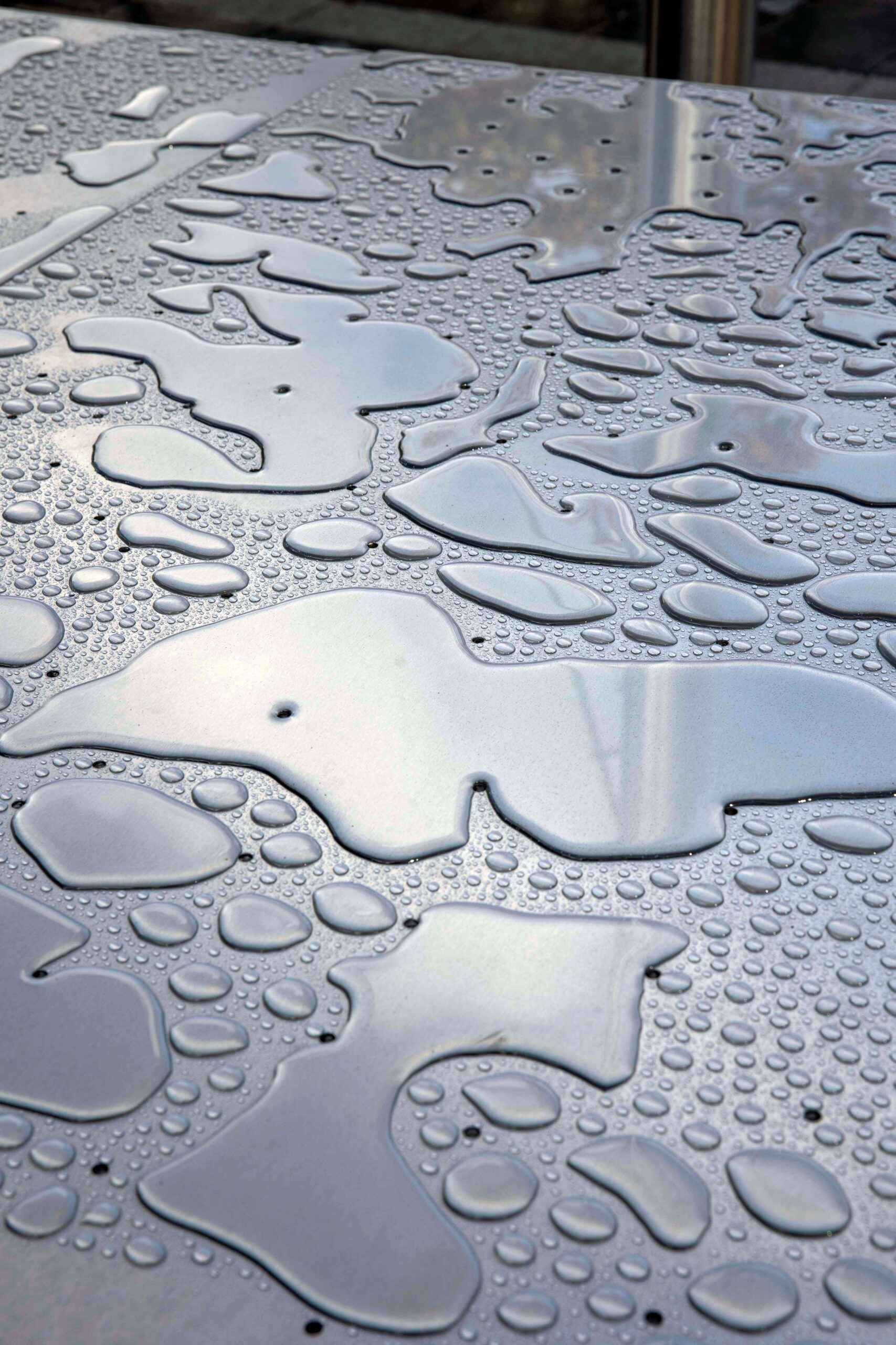 Water drops pooling on table top of Urban Mirror sculptural work in Cork City Centre