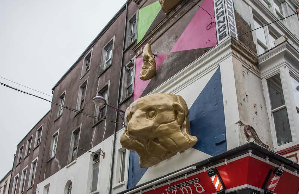 Side view of the three elements of Fiona Mulhollands public artwork. Face Cup on the corner of Princes Street. and Oliver Plunkett Street